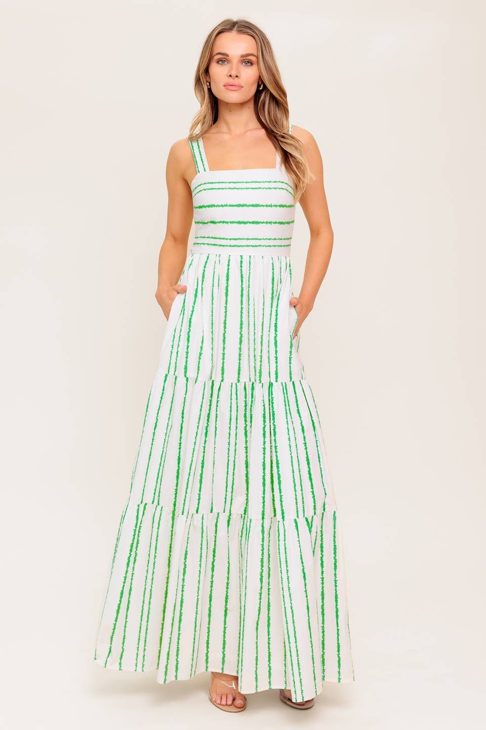 A printed woven maxi dress featuring straight neckline, straps, tiered skirt and smocked back bodice.