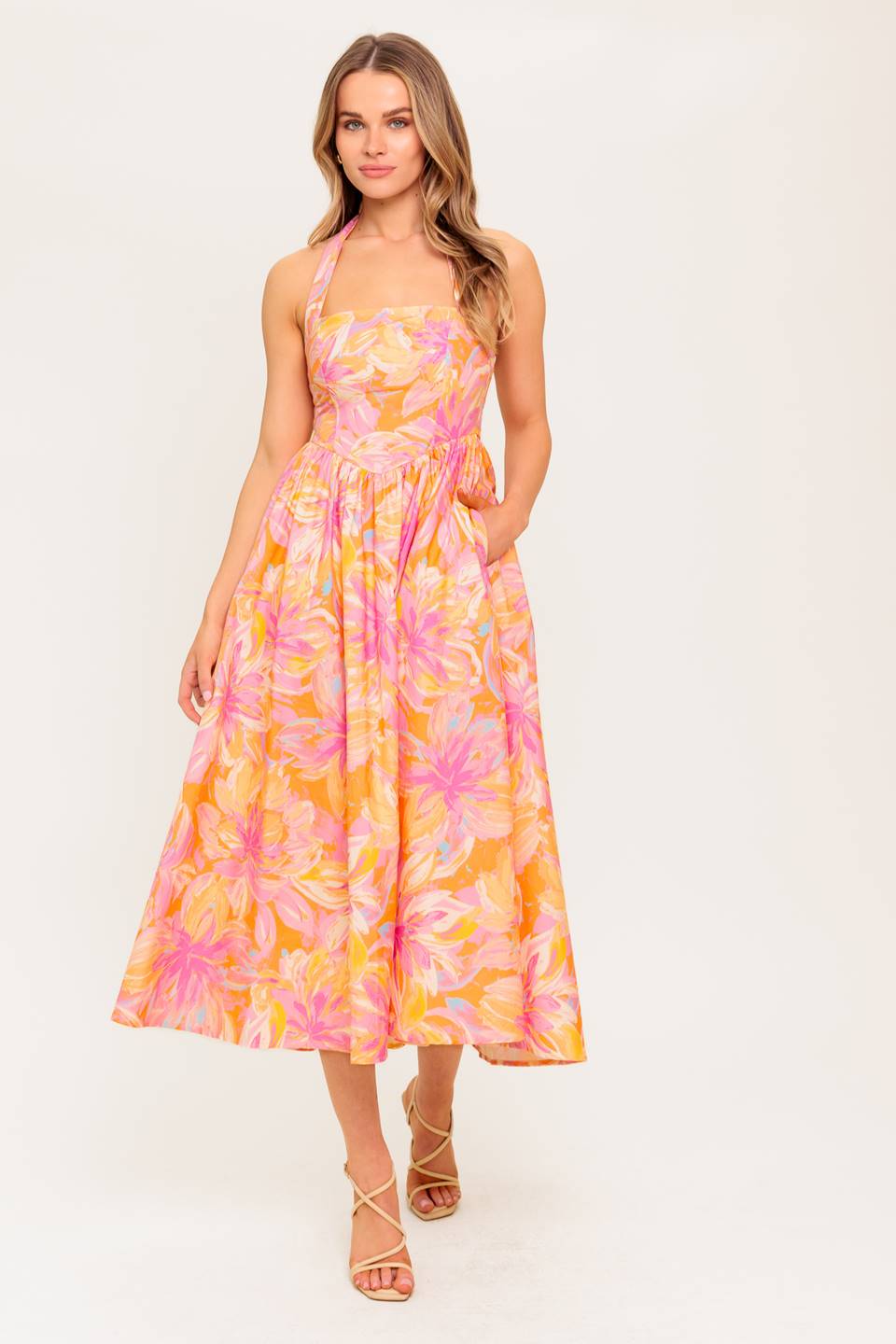 A printed woven midi dress featuring halter neckline, full skirt and smocked back bodice.