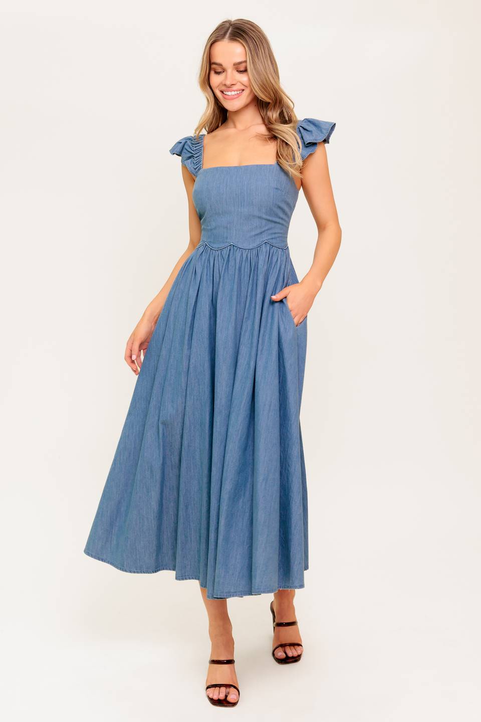 A chambray midi dress featuring square neckline, short ruffle sleeve, full skirt and smocked back bodice.