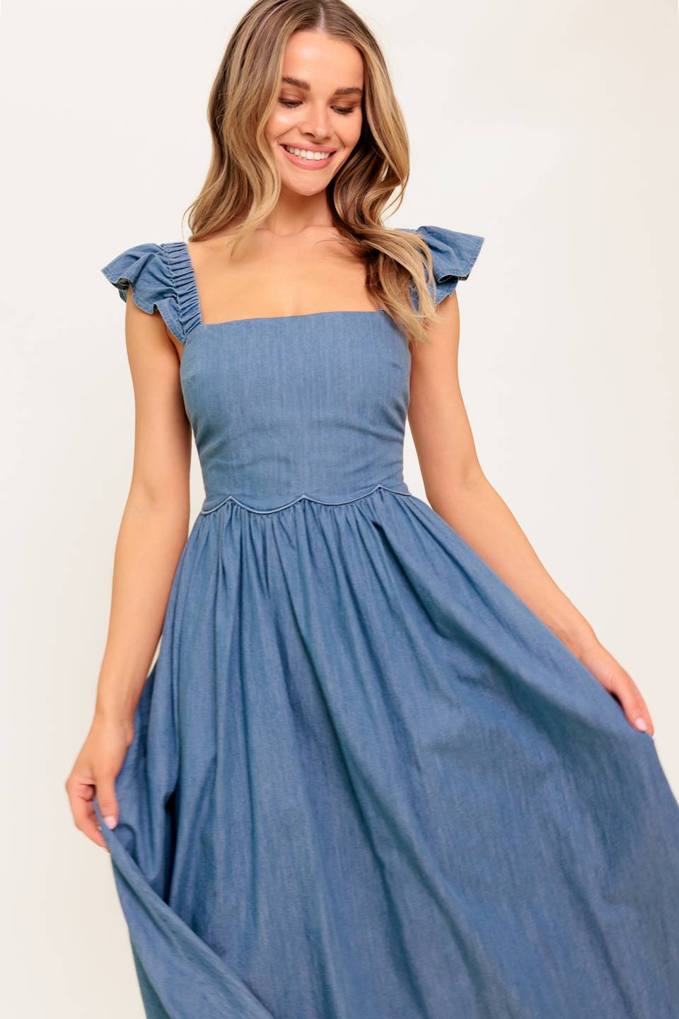 A chambray midi dress featuring square neckline, short ruffle sleeve, full skirt and smocked back bodice.