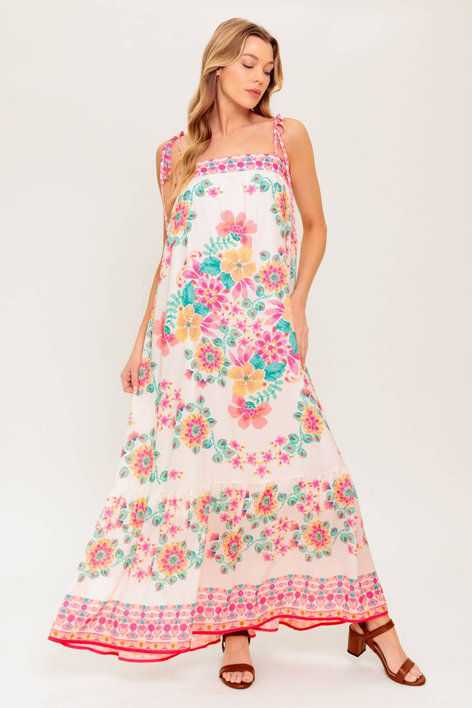 A printed woven maxi dress featuring straight neckline, shoulder tie and ruffled hem