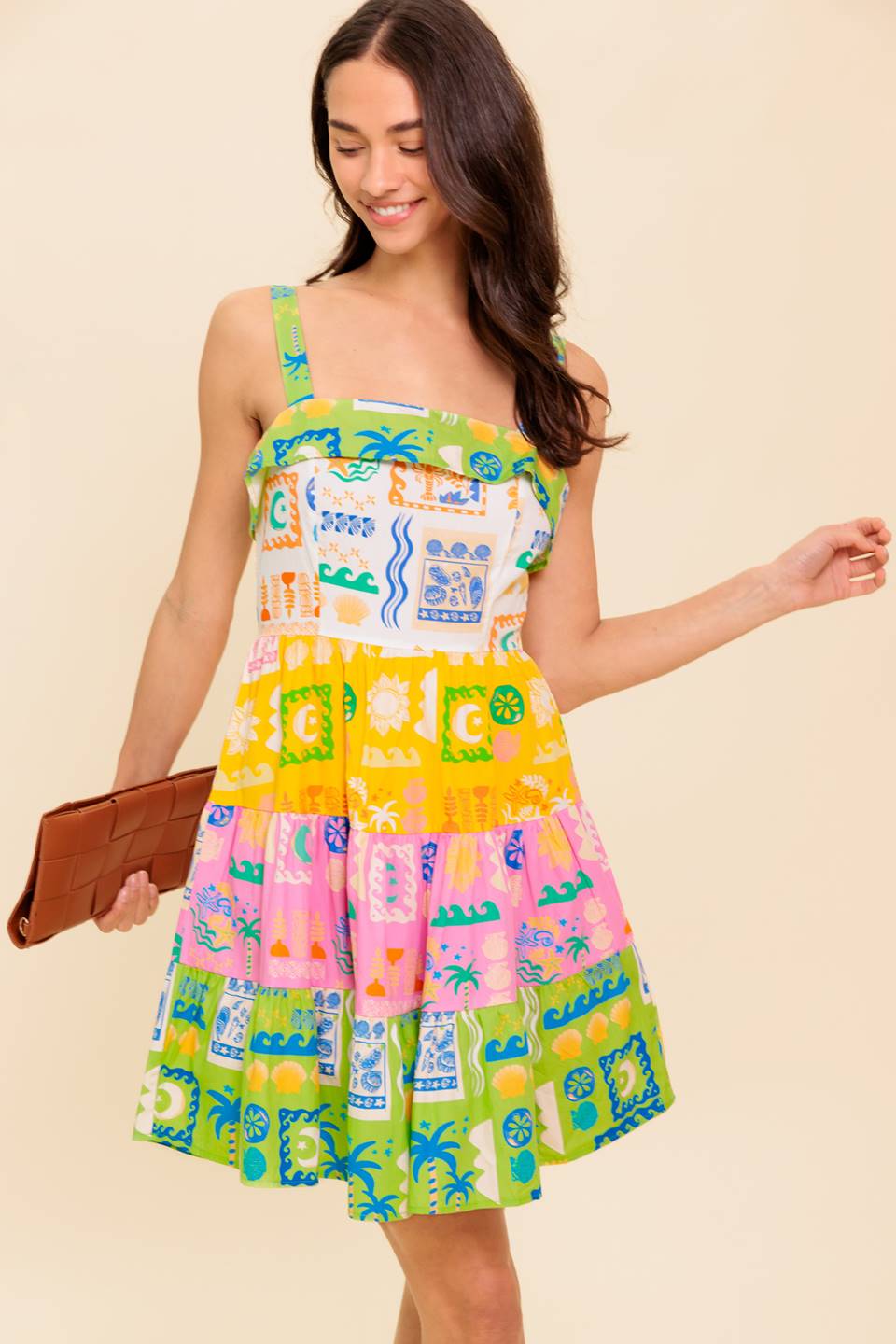 A printed woven mini dress featuring straight neckline, straps, tiered skirt and back zipper closure
