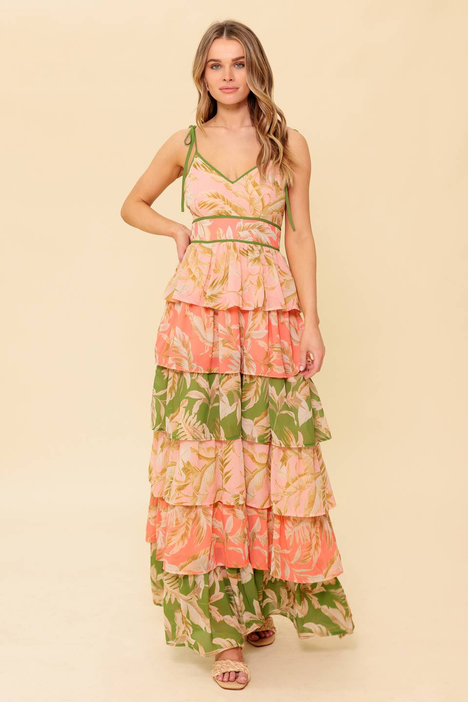 A printed woven maxi dress featuring V neckline, sleeveless, shoulder tie, layered skirt and back zipper closure