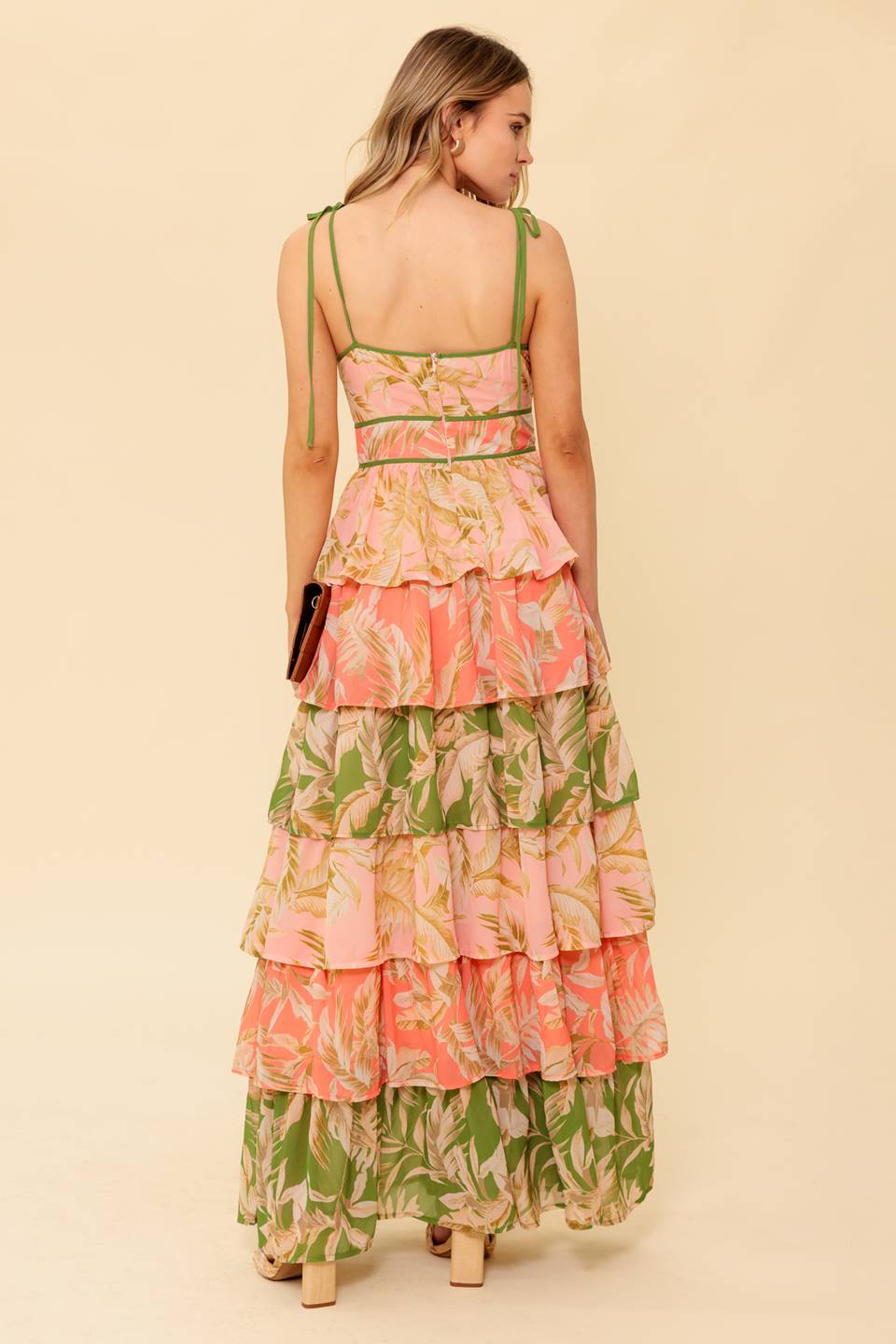 A printed woven maxi dress featuring V neckline, sleeveless, shoulder tie, layered skirt and back zipper closure