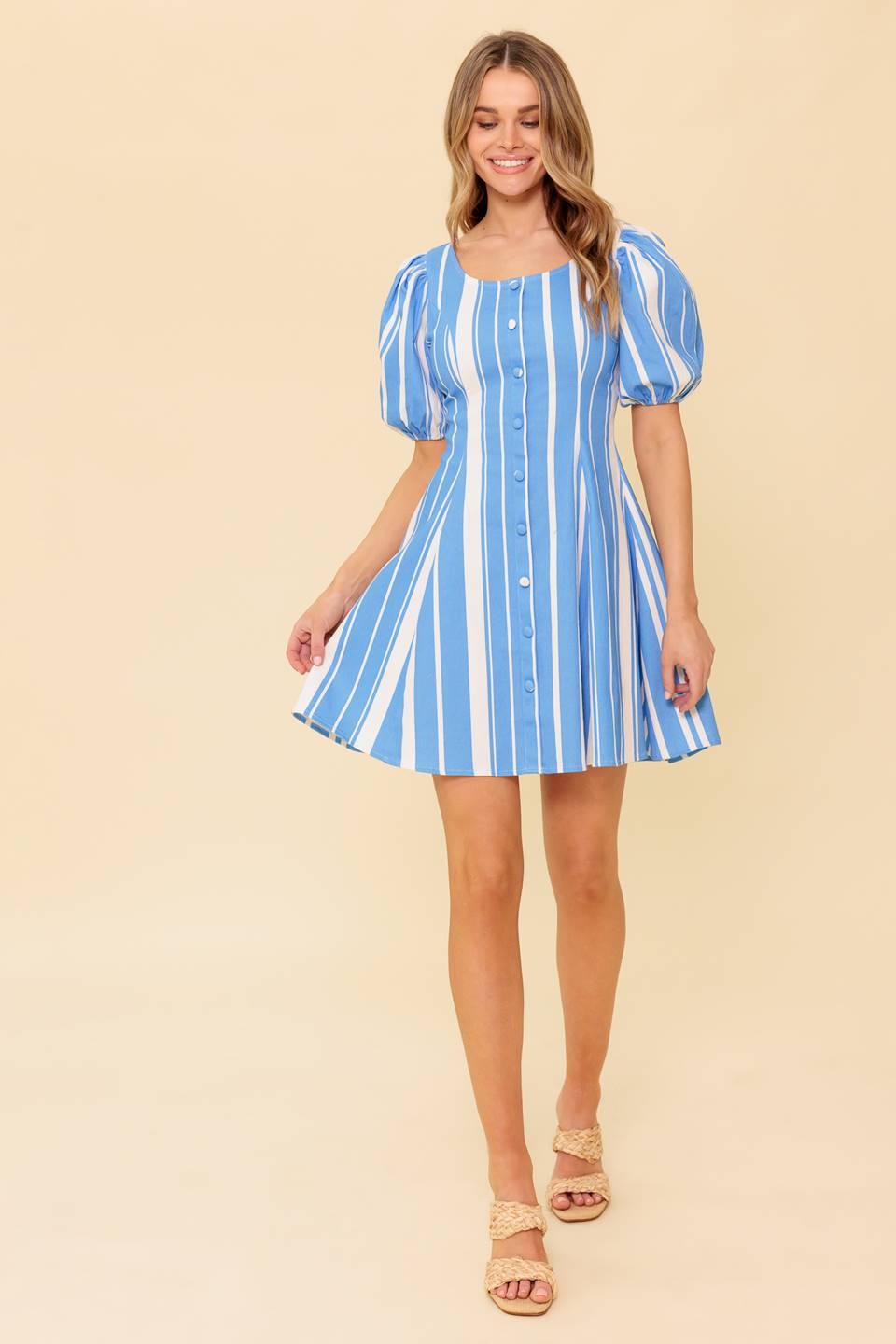 A blue and white stripe, printed woven mini dress featuring wide round neckline, short puff sleeve, front button down detail and back zipper closure