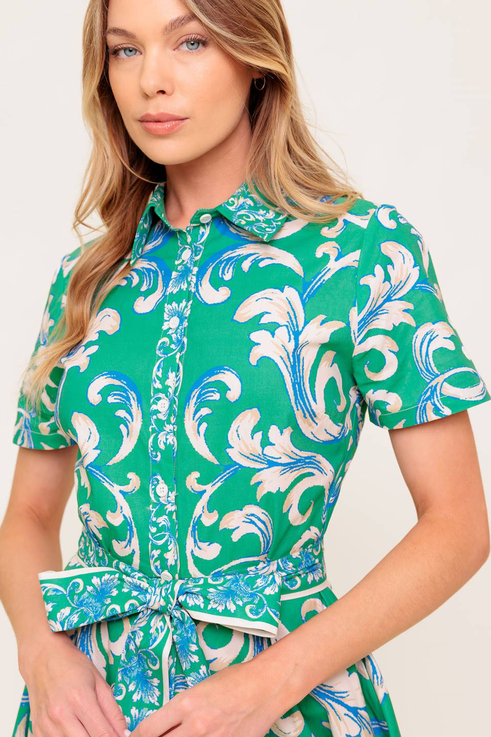 A printed woven midi dress featuring collar, short sleeve, button down, self sash tie and full skirt.