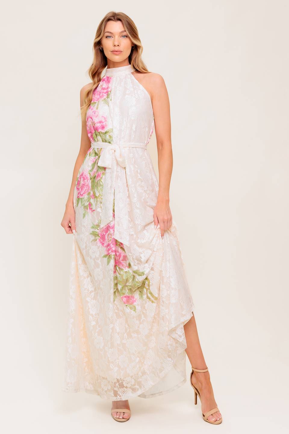 A printed woven lace maxi dress featuring halter neckline, self sash tie and back button closure.