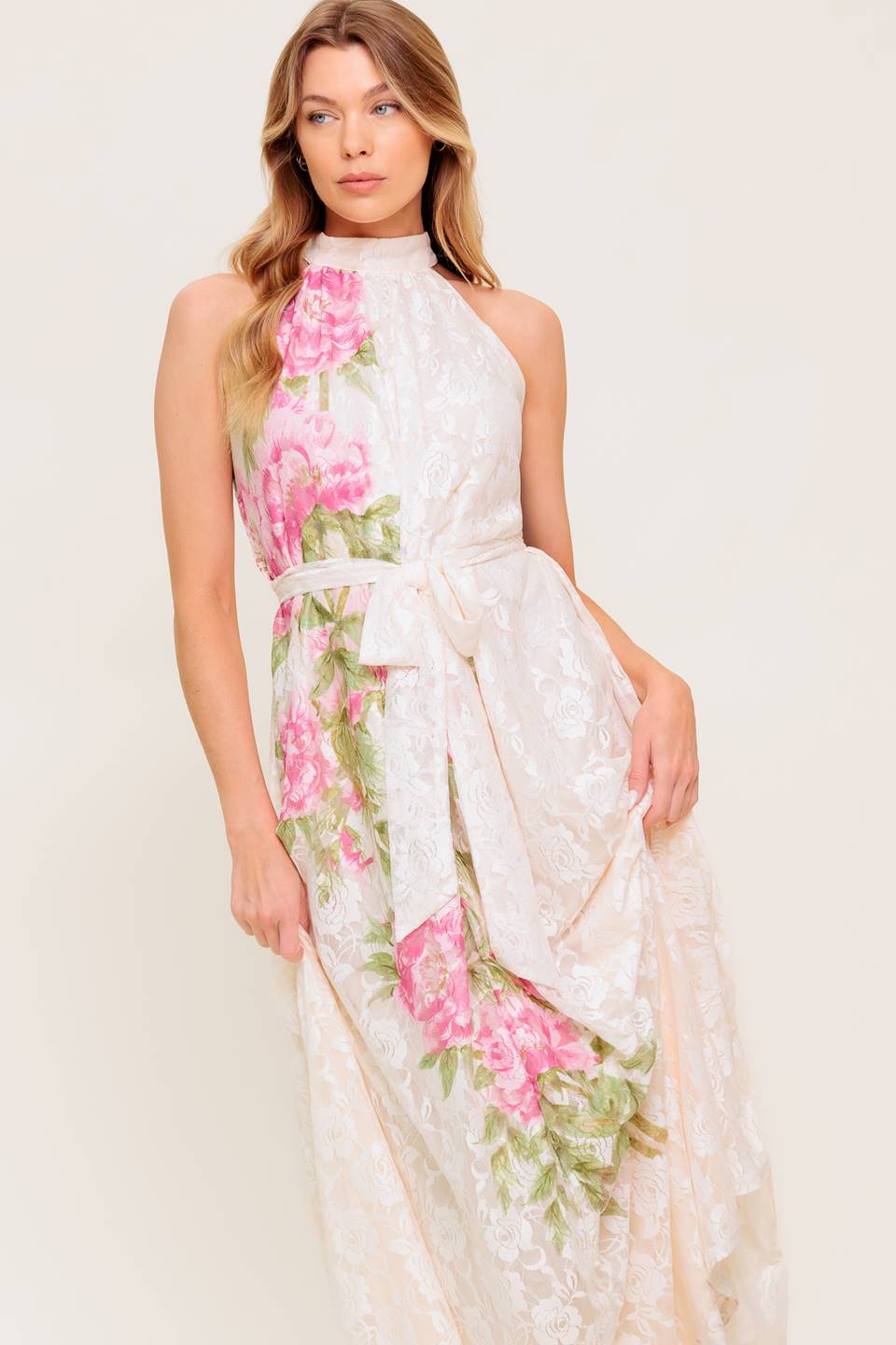 A printed woven lace maxi dress featuring halter neckline, self sash tie and back button closure.
