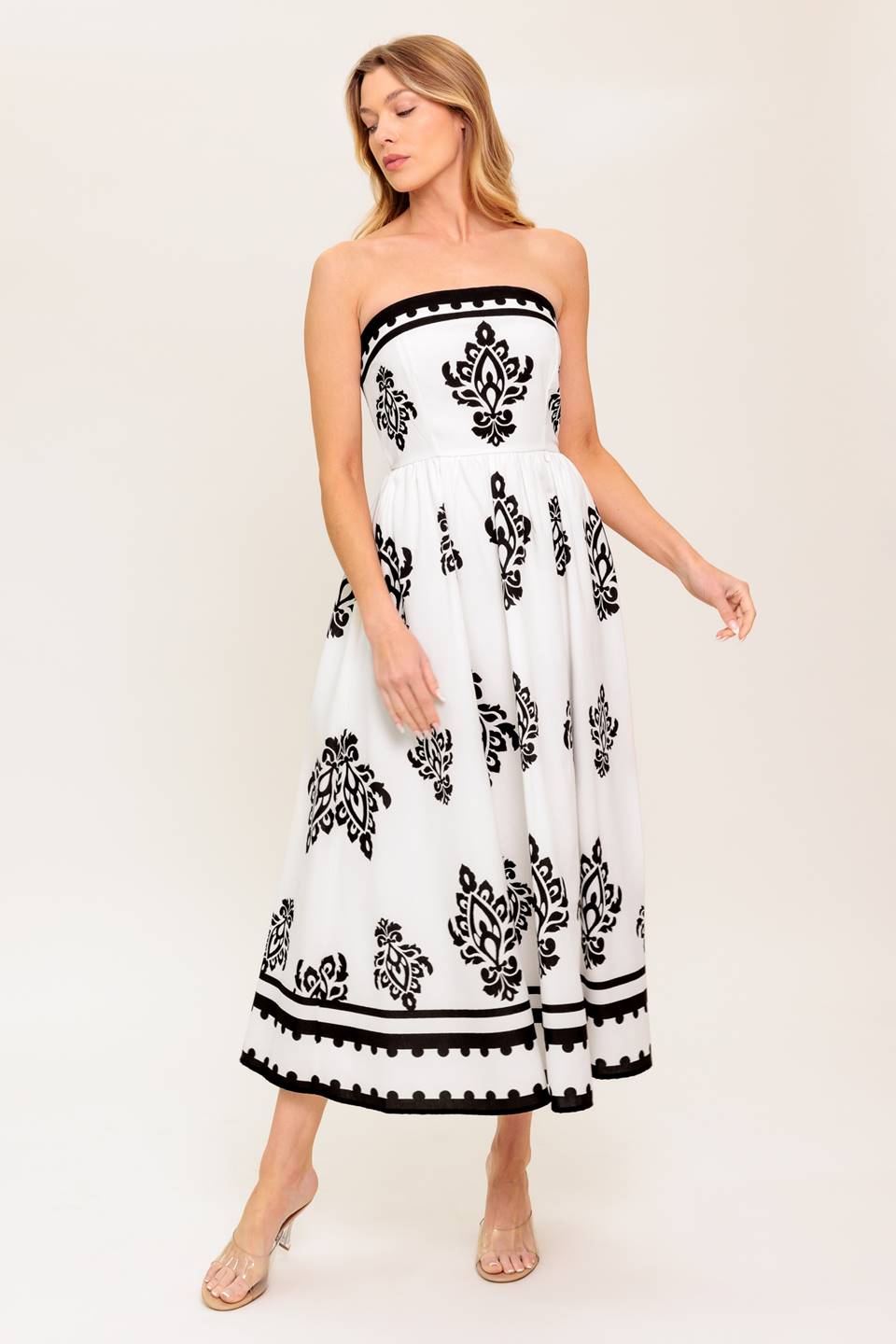 A strapless, white and black printed woven midi dress featuring full skirt and smocked back bodice