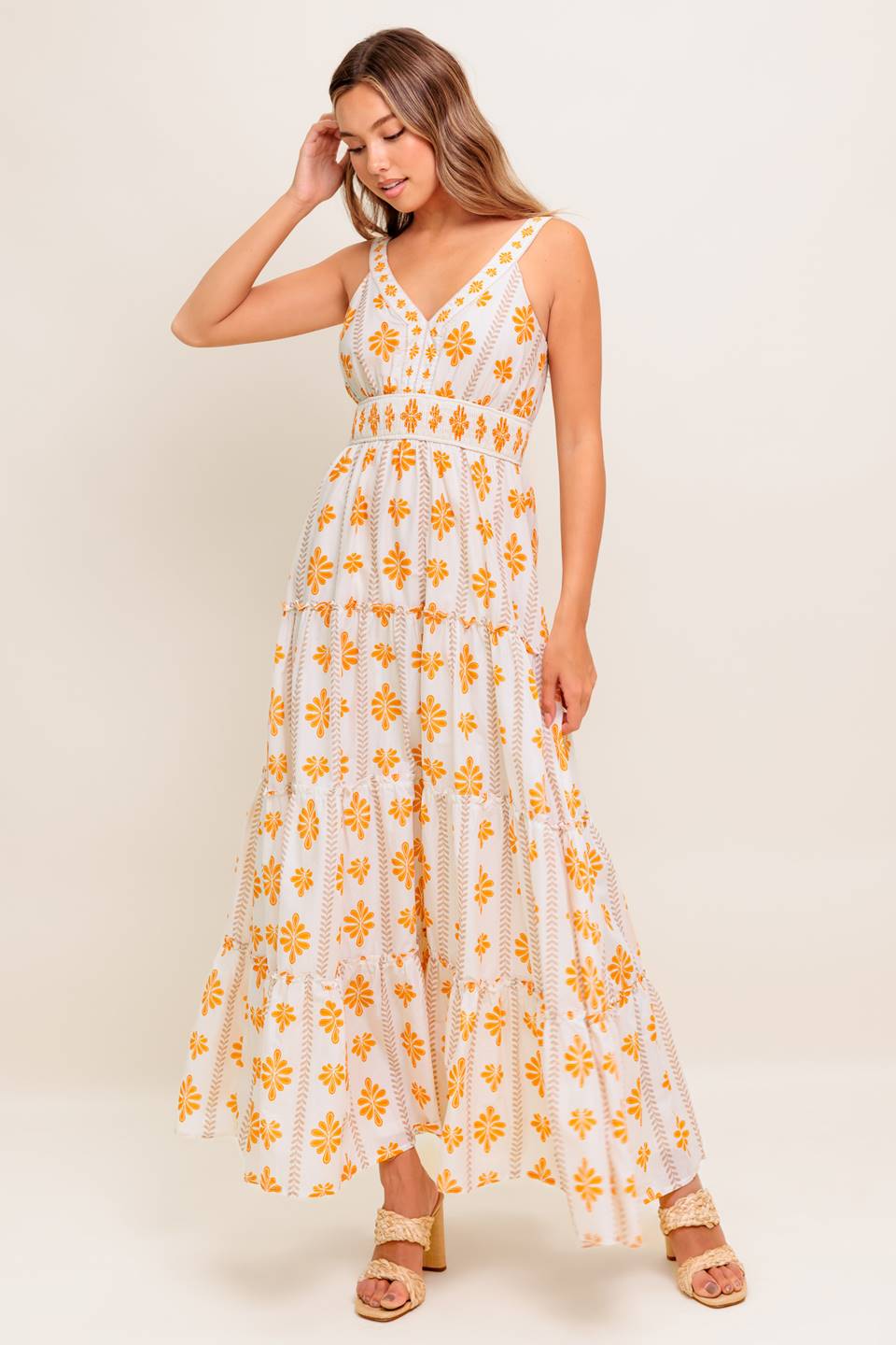 A printed woven maxi dress featuring V neckline, smocked waistband and tiered skirt with ruffled edge.