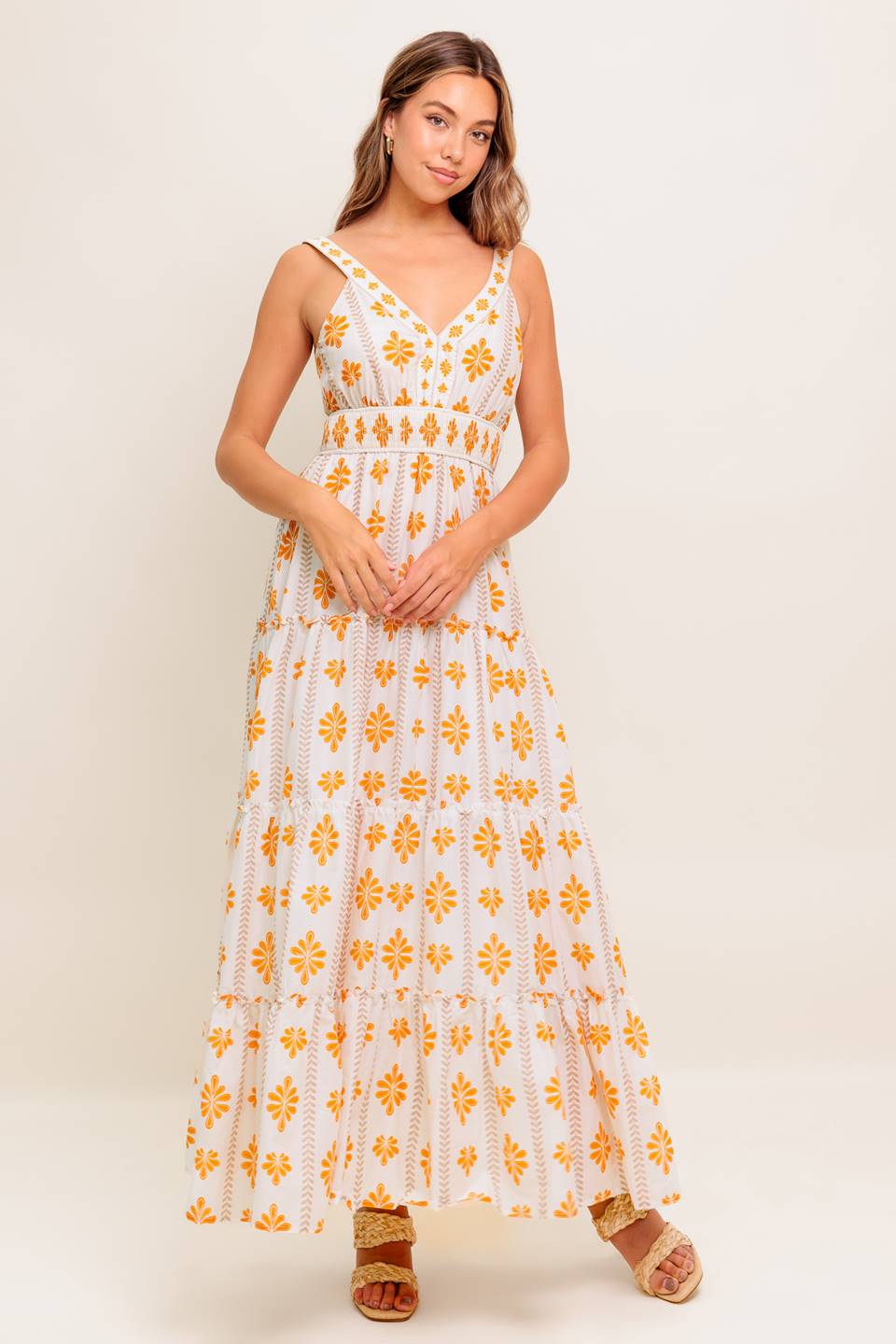 A printed woven maxi dress featuring V neckline, smocked waistband and tiered skirt with ruffled edge.