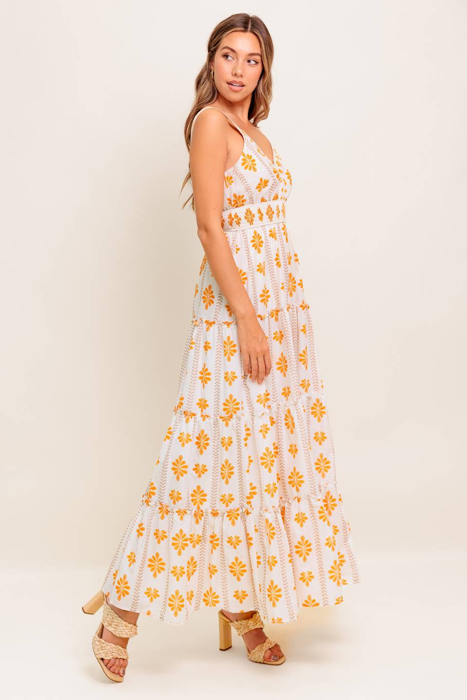 A printed woven maxi dress featuring V neckline, smocked waistband and tiered skirt with ruffled edge.