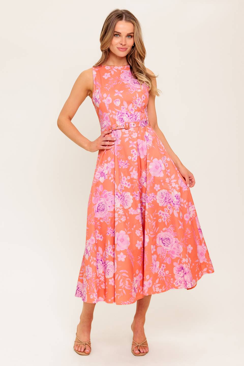A printed woven midi dress featuring round neckline, sleeveless, self belt, circle skirt and back zipper closure.