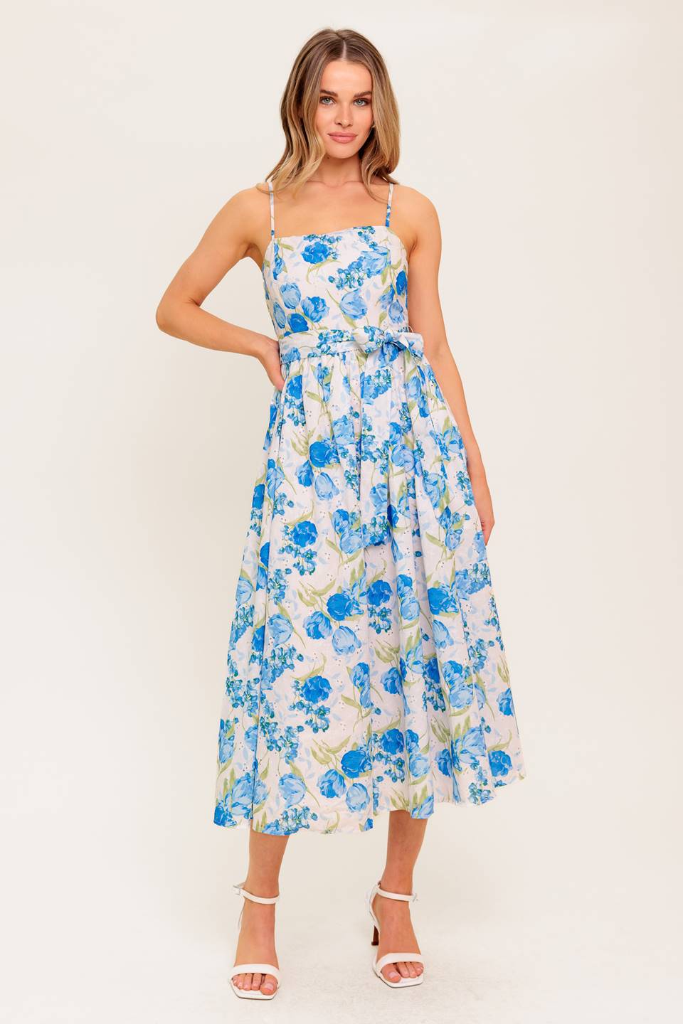 A floral printed woven midi dress featuring straight neckline, straps, self sash tie, full skirt and smocked back bodice.