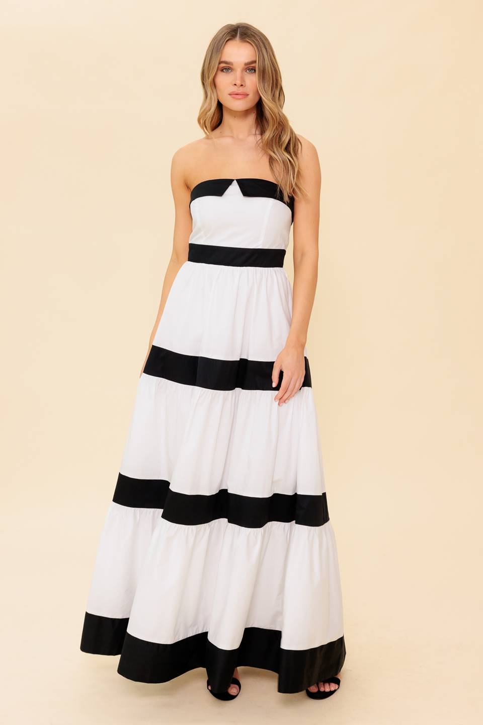 A solid color blocked maxi dress featuring tiered skirt and back zipper closure
