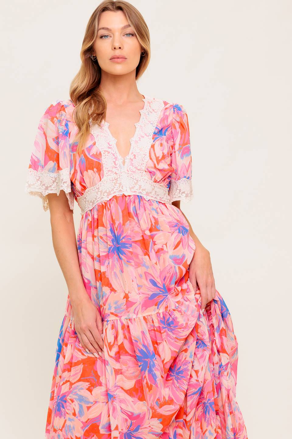 A printed woven maxi dress featuring lace trimmed V neckline, short flutter sleeve with lace hem, lace waistband, tiered skirt and smocked back waistband.