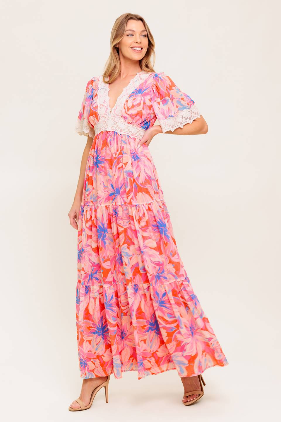 A printed woven maxi dress featuring lace trimmed V neckline, short flutter sleeve with lace hem, lace waistband, tiered skirt and smocked back waistband.