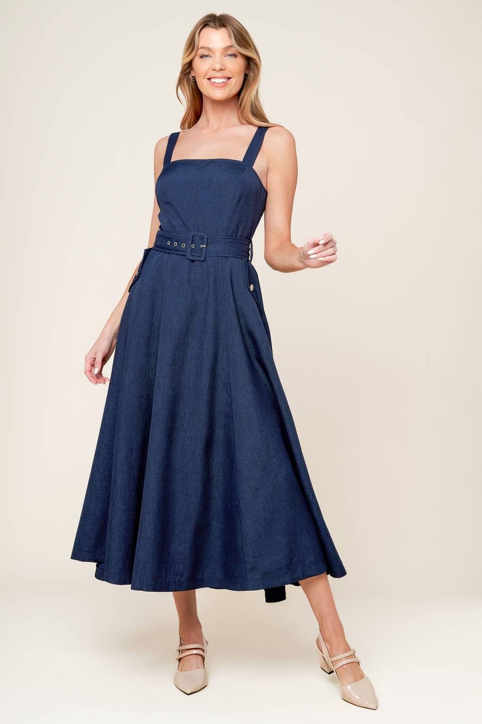 A solid woven midi dress featuring straight neckline, straps, self belt, side pockets, full skirt and back zipper closure