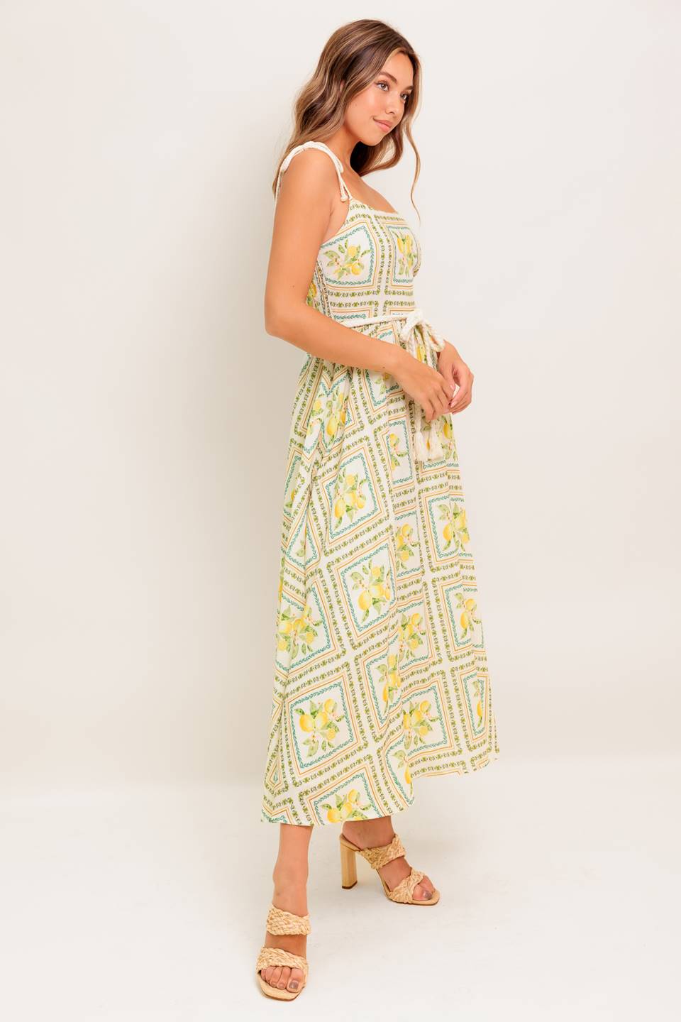 A printed woven midi dress featuring straight neckline, braided straps and belt, circle skirt and smocked back bodice