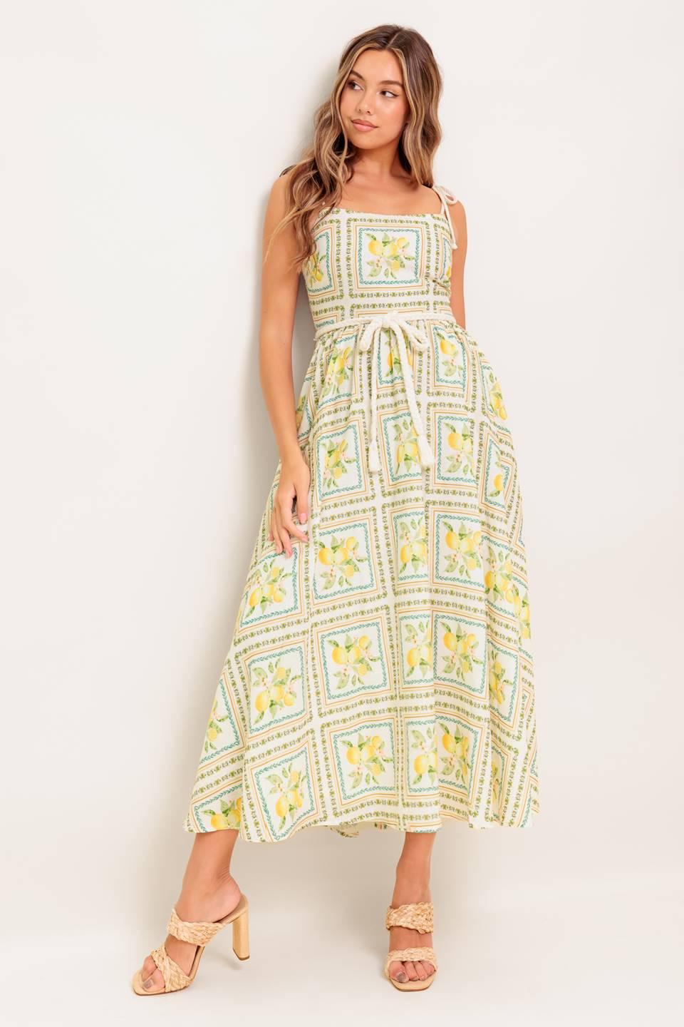A printed woven midi dress featuring straight neckline, braided straps and belt, circle skirt and smocked back bodice