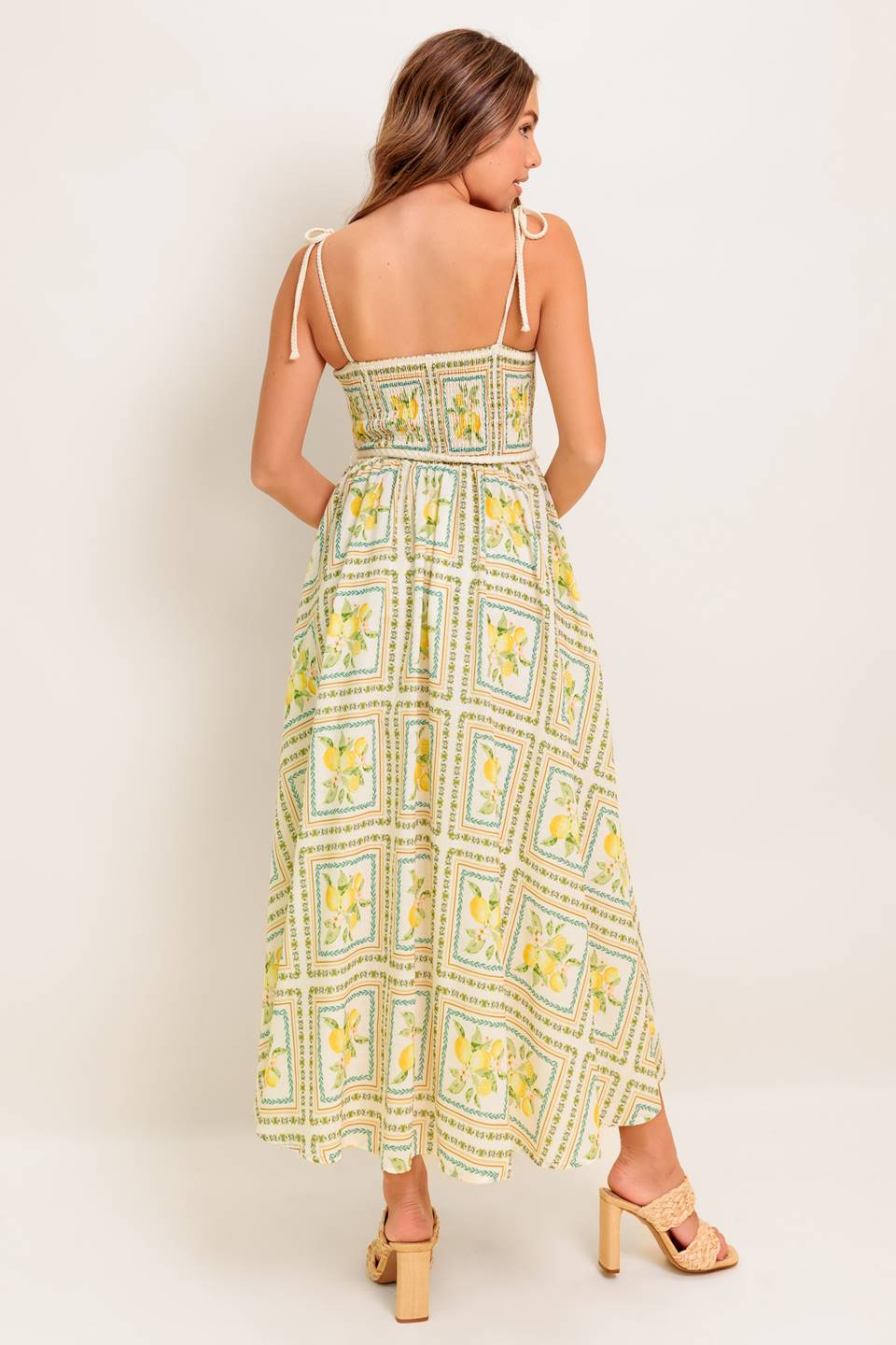 A printed woven midi dress featuring straight neckline, braided straps and belt, circle skirt and smocked back bodice