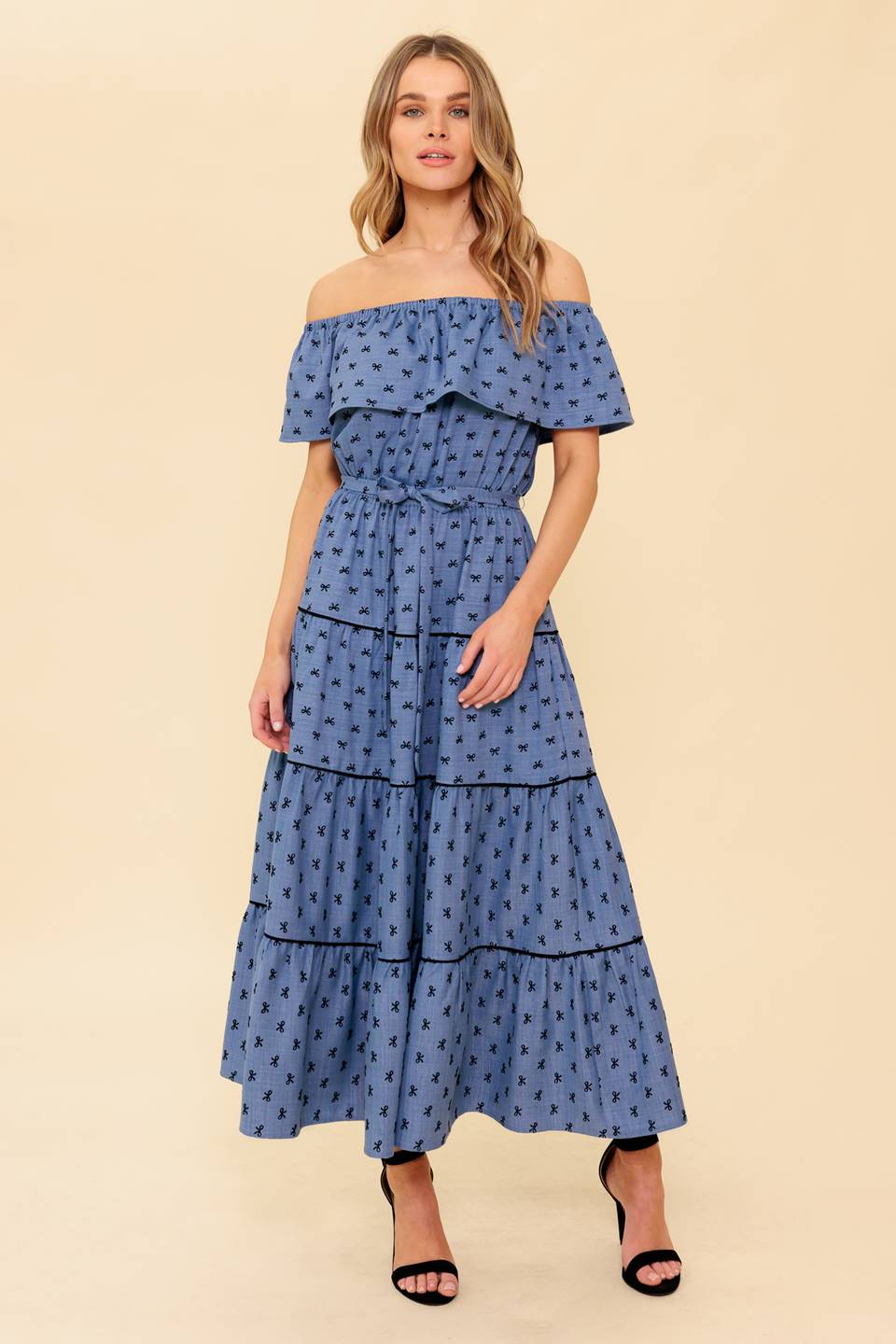 A textured woven midi dress featuring off shoulder neckline, flounce, elasticized waist, self sash tie and tiered skirt