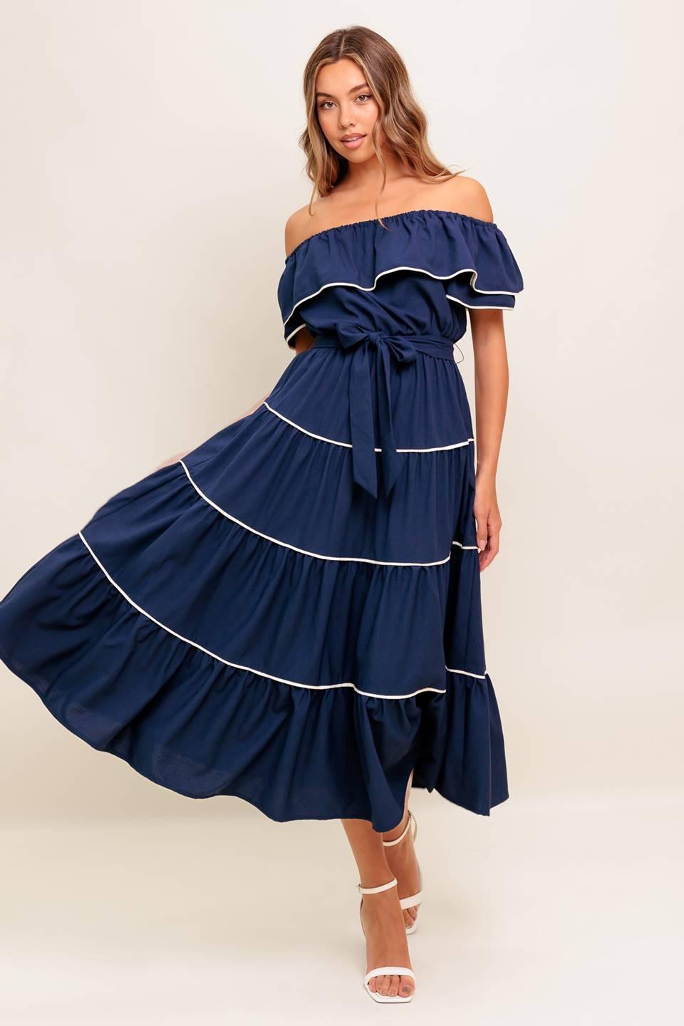 A solid navy woven midi dress featuring off shoulder neckline with flounce, elasticized waist, self sash tie and tiered skirt
