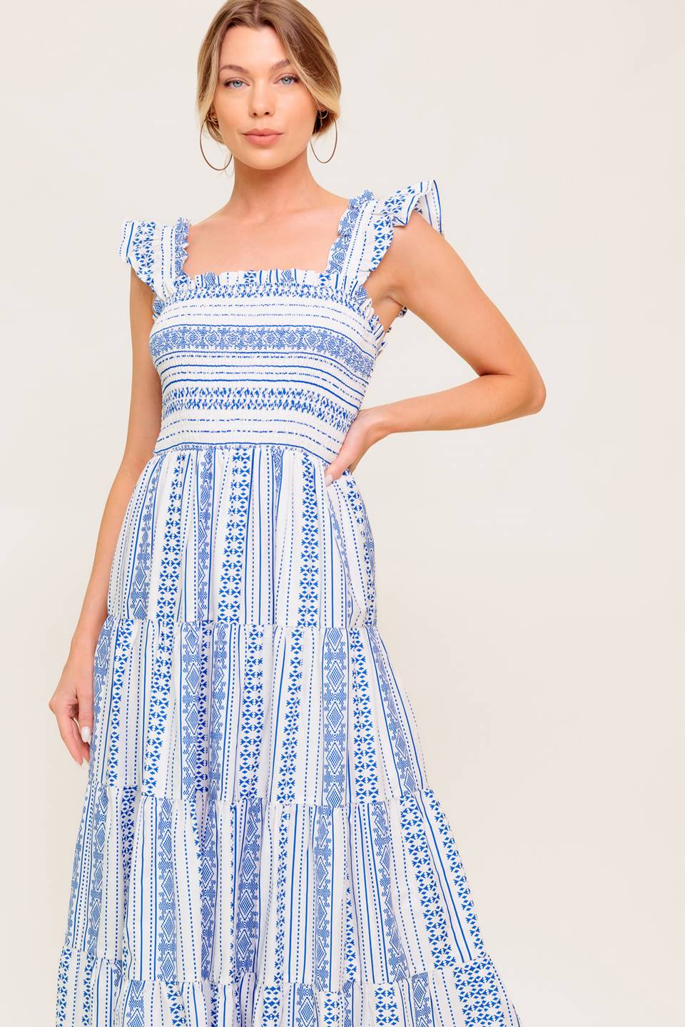 A printed woven midi dress featuring square neckline, ruffled sleeve, smocked bodice and tiered skirt.