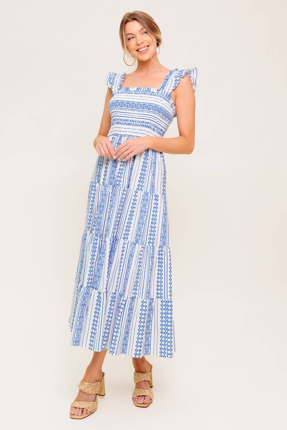 A printed woven midi dress featuring square neckline, ruffled sleeve, smocked bodice and tiered skirt.