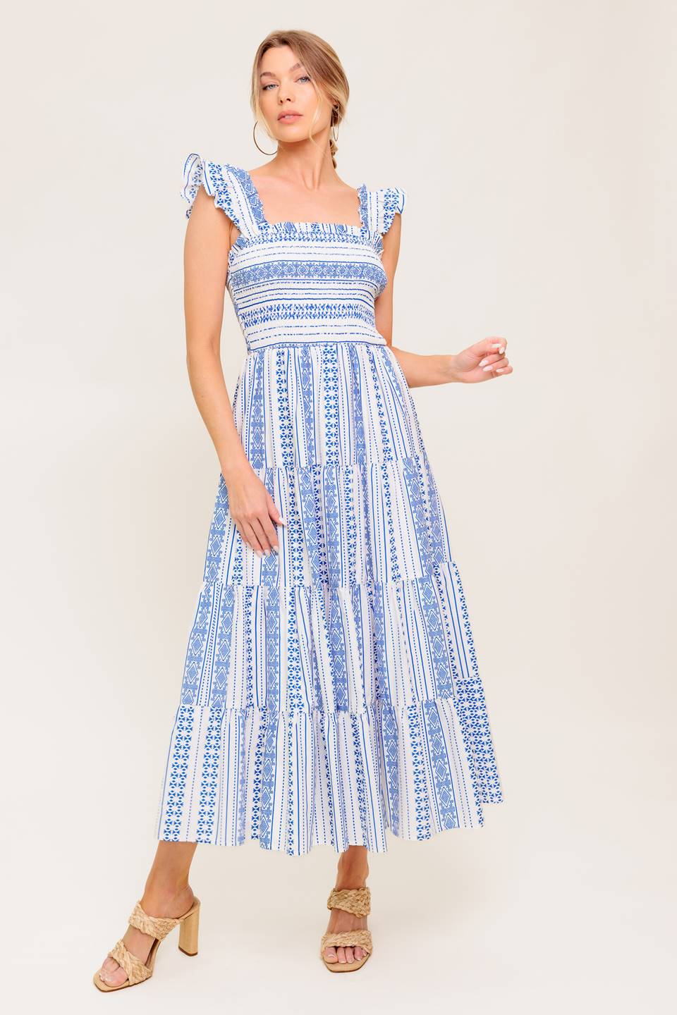 A printed woven midi dress featuring square neckline, ruffled sleeve, smocked bodice and tiered skirt.
