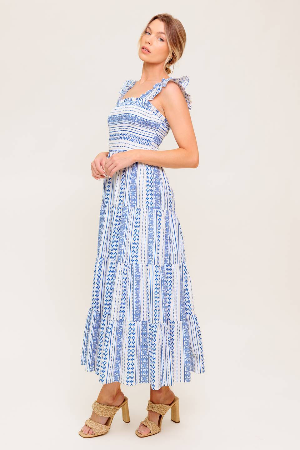 A printed woven midi dress featuring square neckline, ruffled sleeve, smocked bodice and tiered skirt.