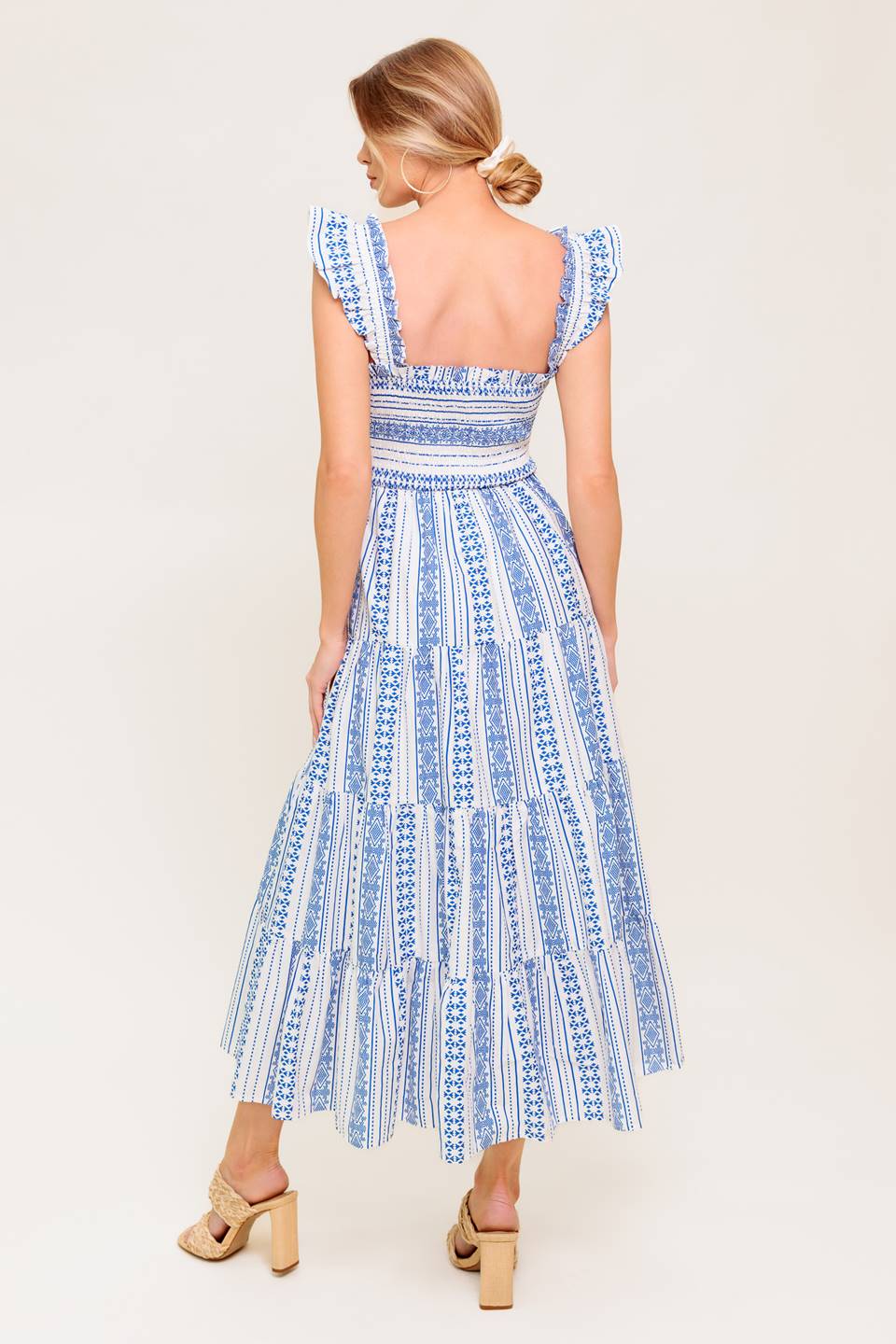 A printed woven midi dress featuring square neckline, ruffled sleeve, smocked bodice and tiered skirt.