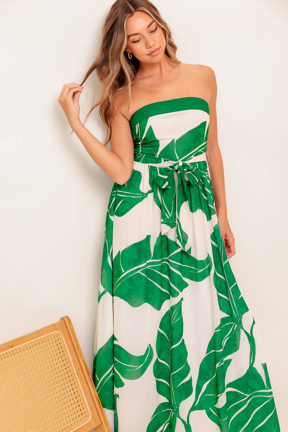 A printed woven ankle dress featuring strapless, self sash tie, full skirt and smocked back bodice