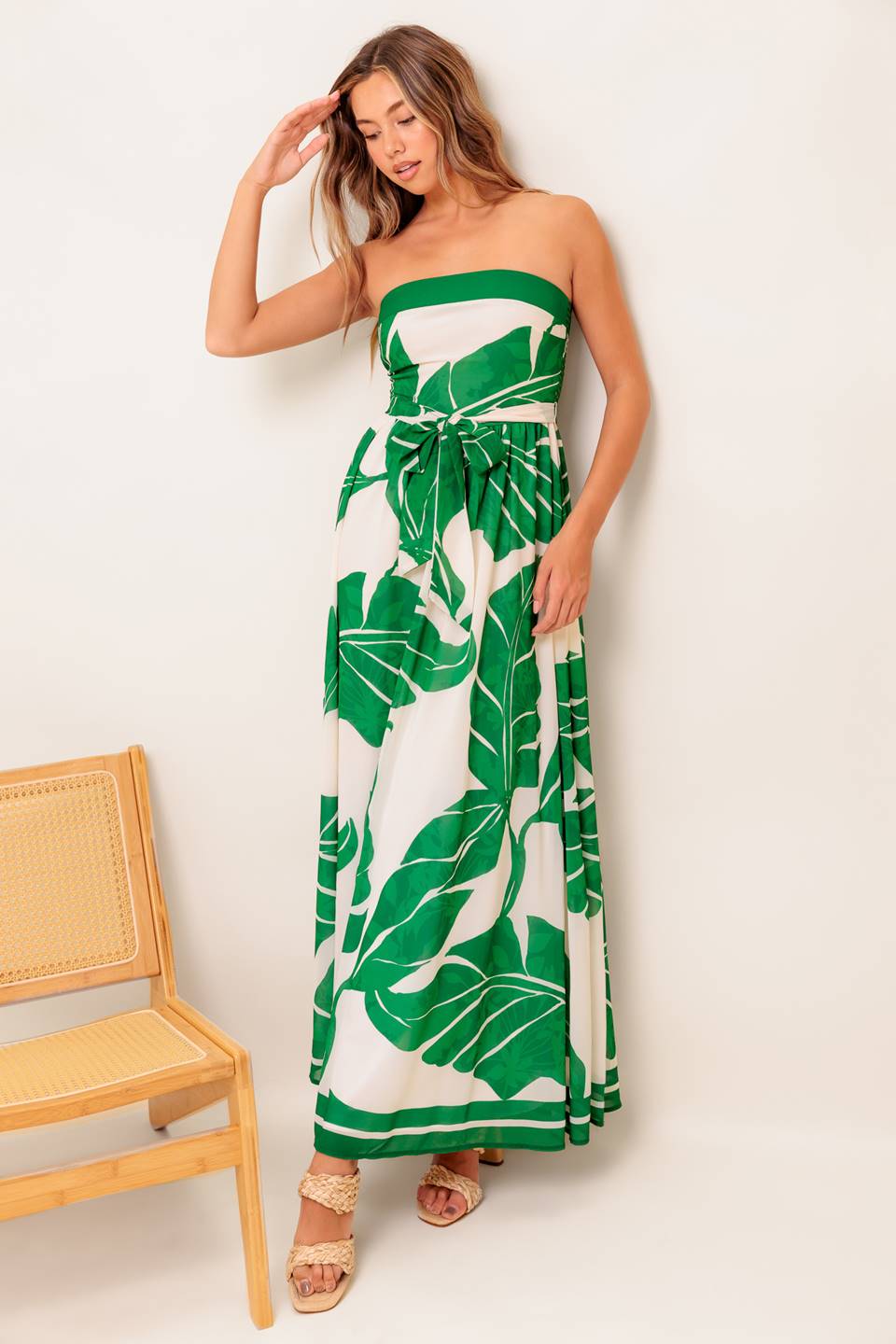 A printed woven ankle dress featuring strapless, self sash tie, full skirt and smocked back bodice