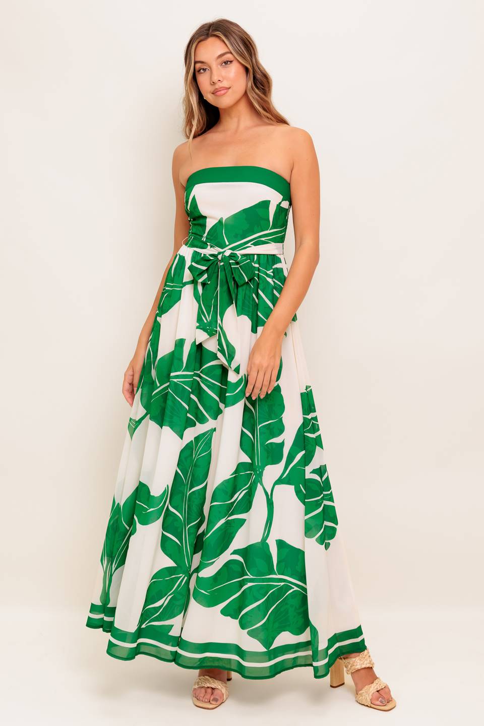 A printed woven ankle dress featuring strapless, self sash tie, full skirt and smocked back bodice
