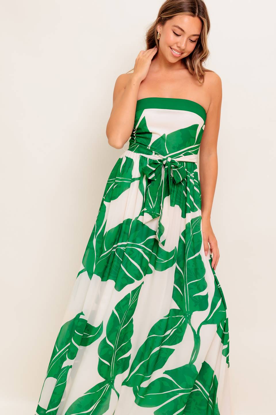 A printed woven ankle dress featuring strapless, self sash tie, full skirt and smocked back bodice