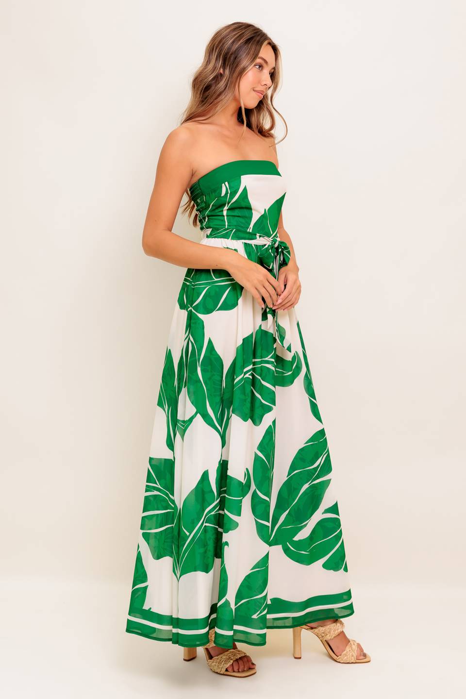 A printed woven ankle dress featuring strapless, self sash tie, full skirt and smocked back bodice
