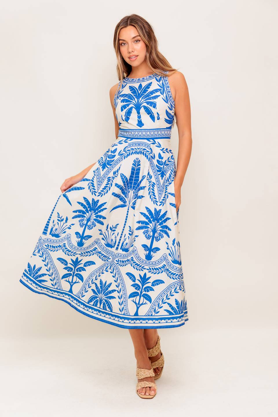 A printed woven midi dress featuring round neckline, sleeveless, circle skirt and tie back with zipper closure