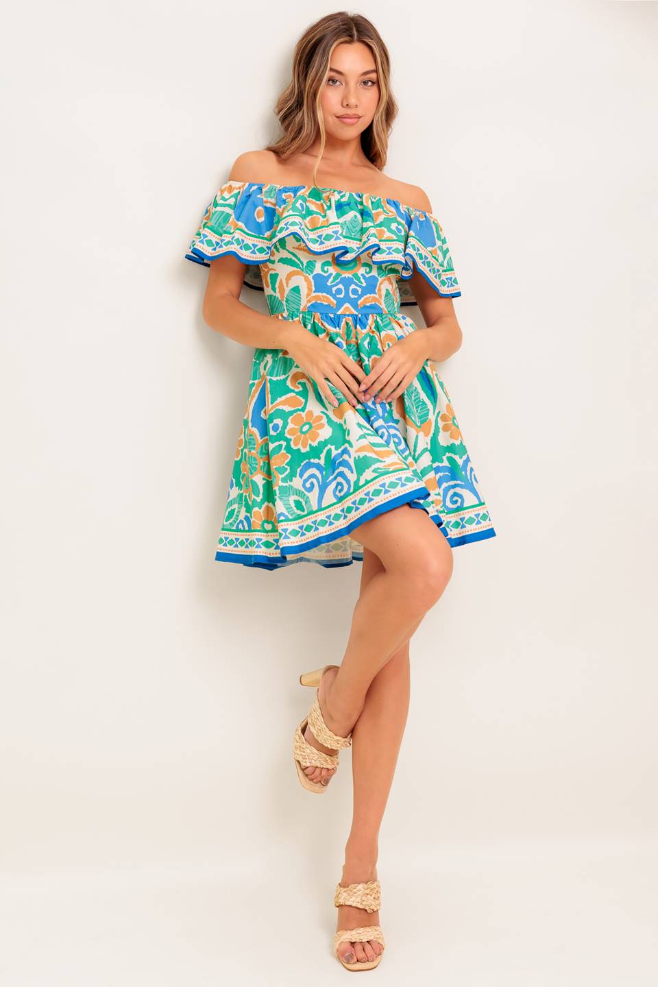 A printed woven mini dress featuring off shoulder neckline, flounce, full skirt and back zipper closure