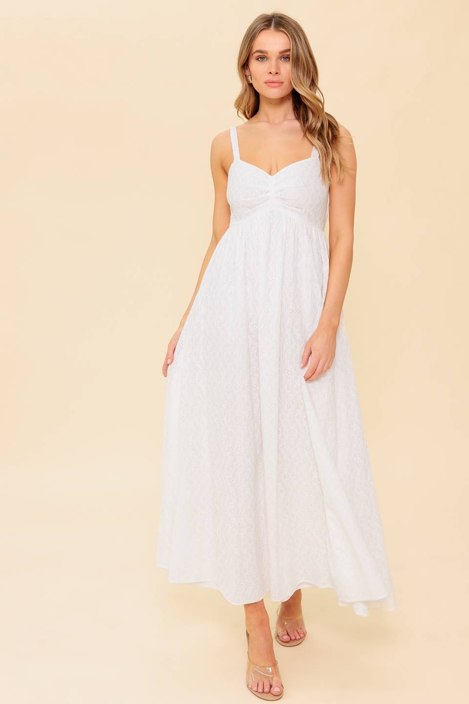 A solid white eyelet midi dress featuring sweetheart neckline, straps, full skirt and smocked back bodice
