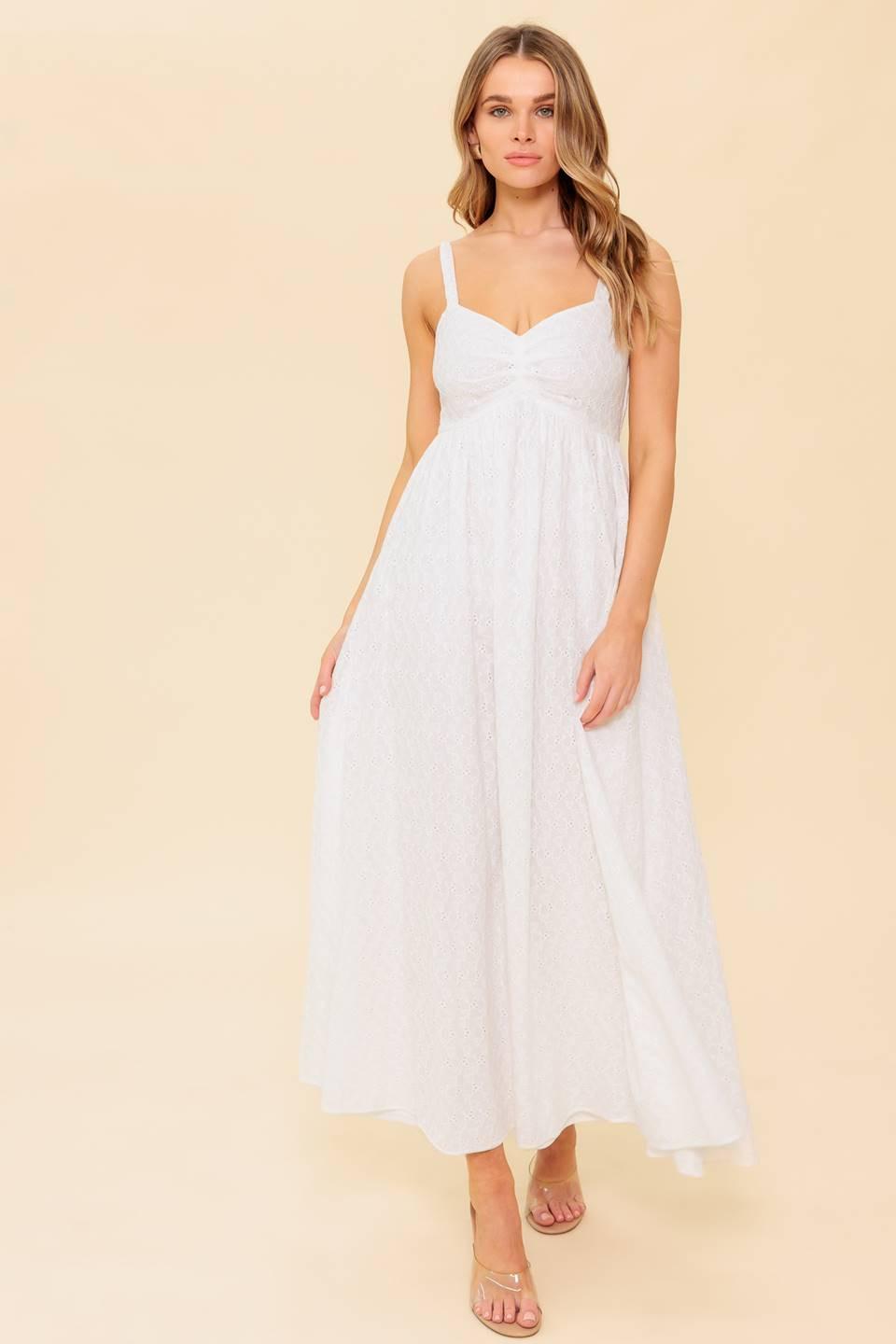A solid white eyelet midi dress featuring sweetheart neckline, straps, full skirt and smocked back bodice