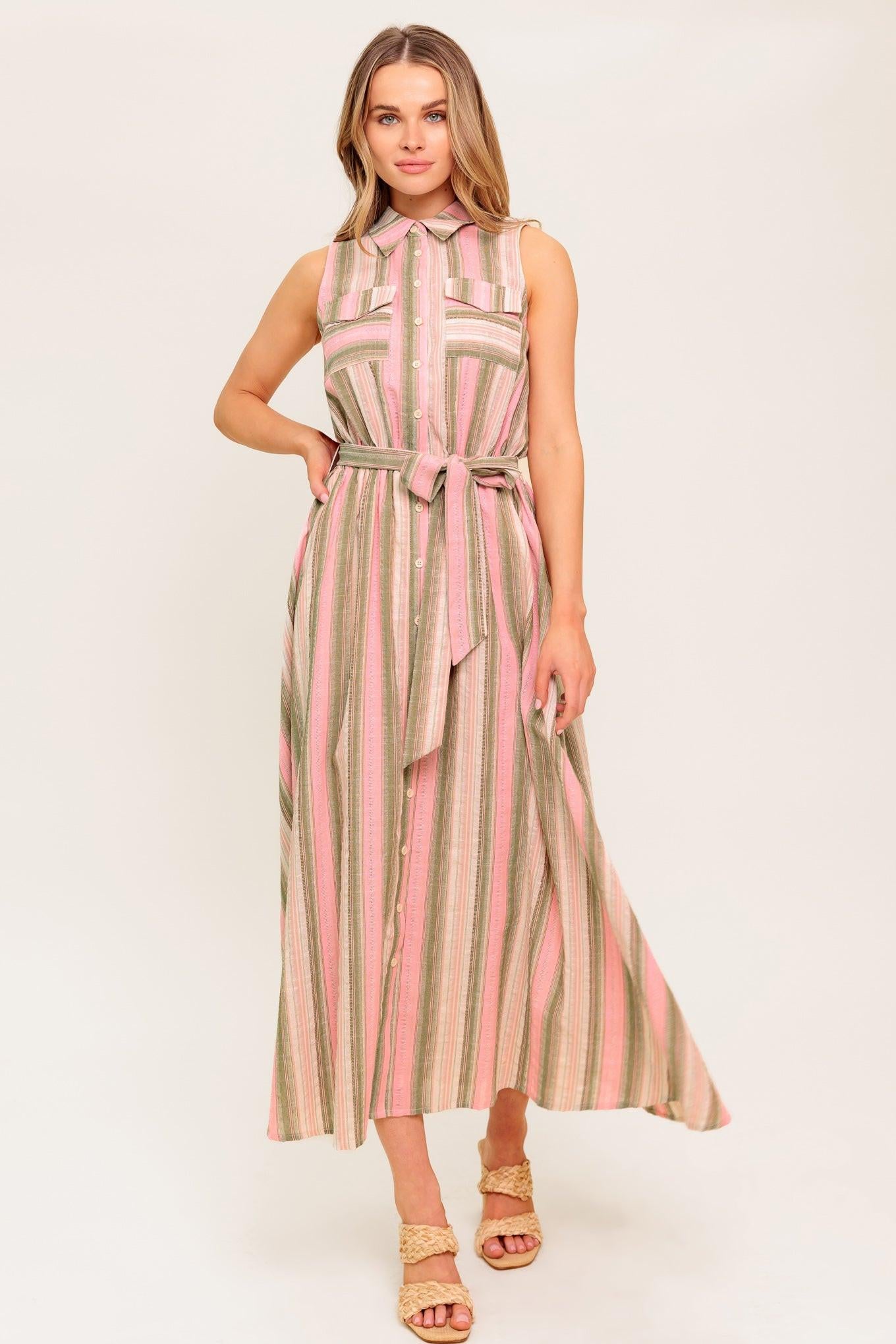 A striped woven midi dress featuring collar, button down, pockets, elasticized waist, self sash and full skirt.