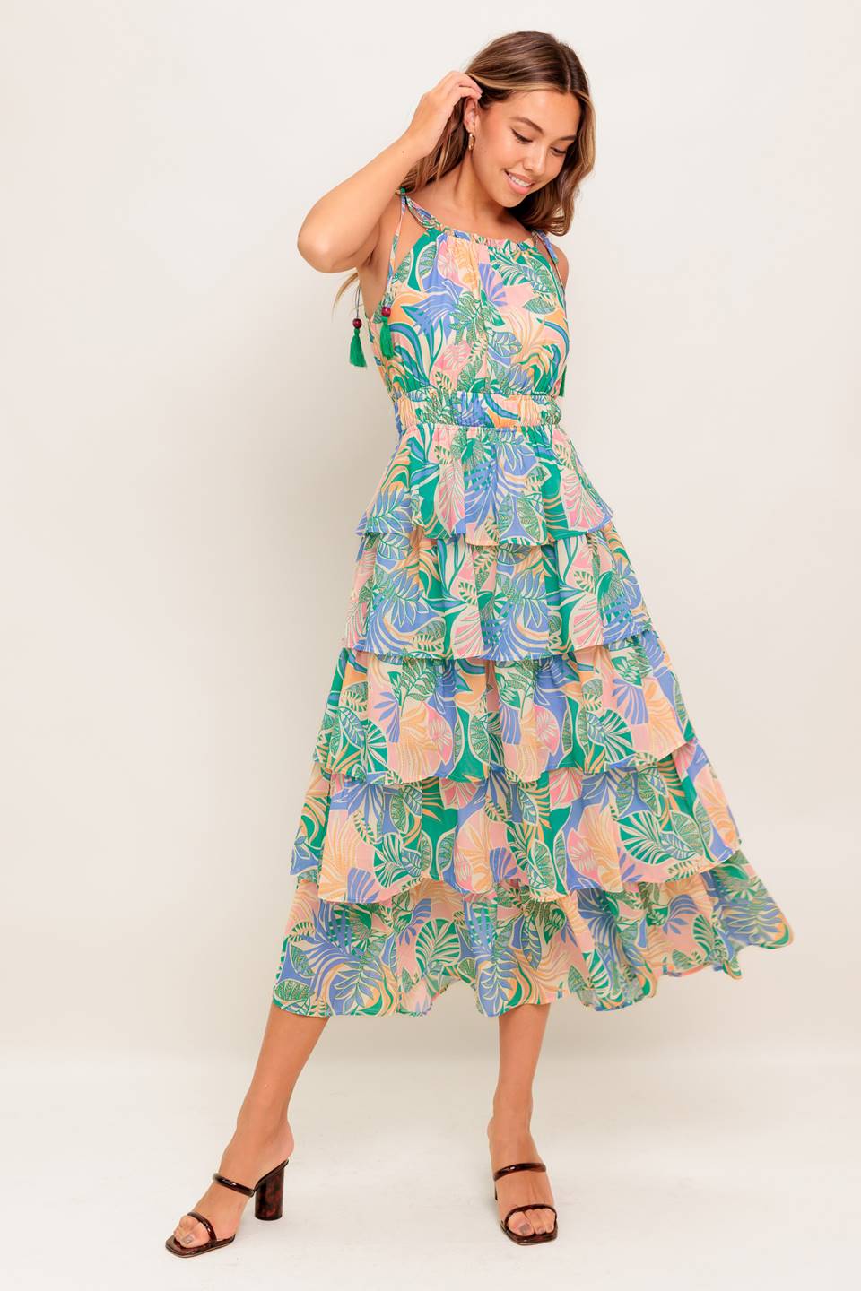 A printed woven midi dress featuring bib neckline with ruffled edge, shoulder ties, elasticized waist and layered skirt