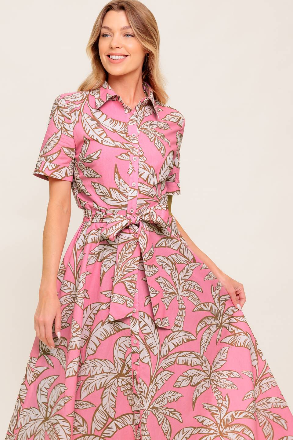 A printed woven midi dress featuring collar, short cuffed sleeve, front button down, self sash tie and full skirt.