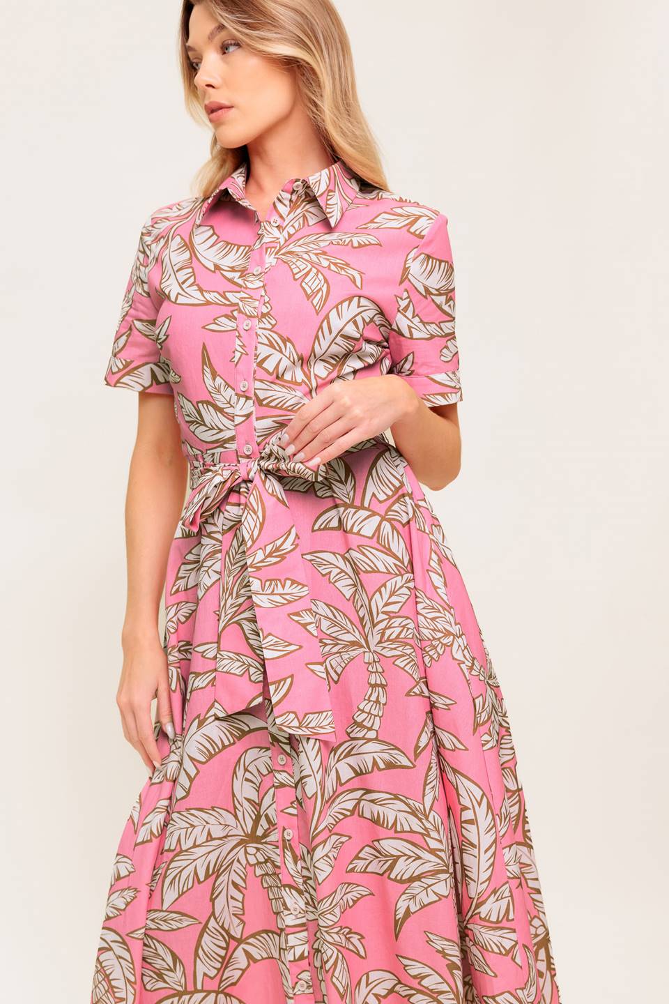 A printed woven midi dress featuring collar, short cuffed sleeve, front button down, self sash tie and full skirt.