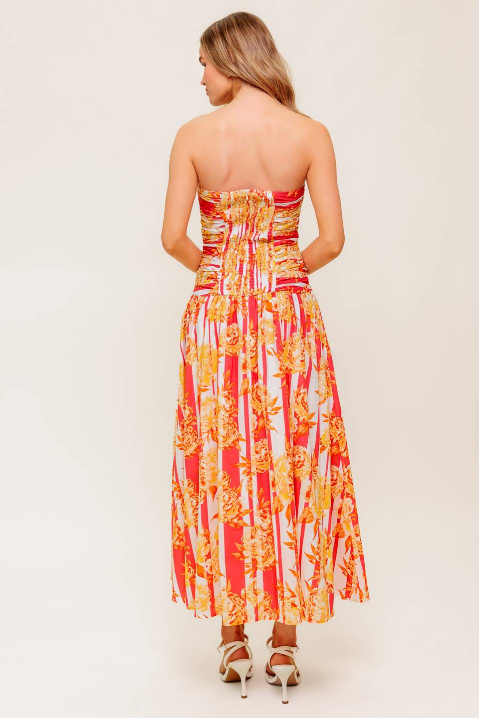 A printed woven midi dress featuring strapless, shirred bodice, full skirt and smock and zipper back closure