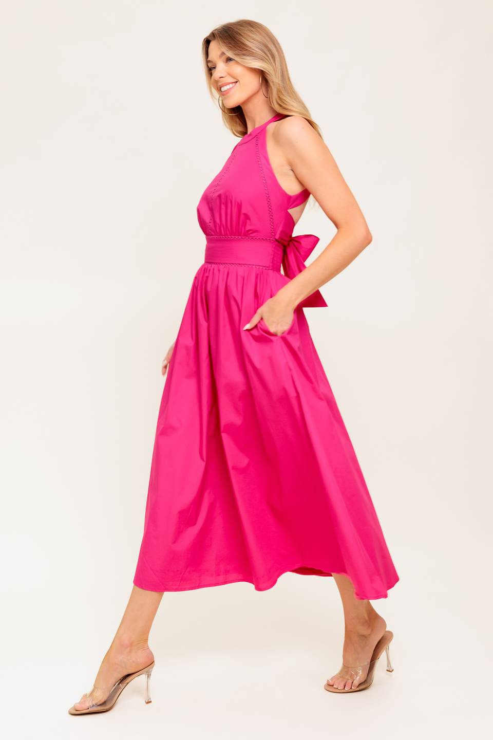 A solid hot pink woven midi dress featuring halter neckline, lace inset detail, smocked back waistband and bare back with button/tie closure.