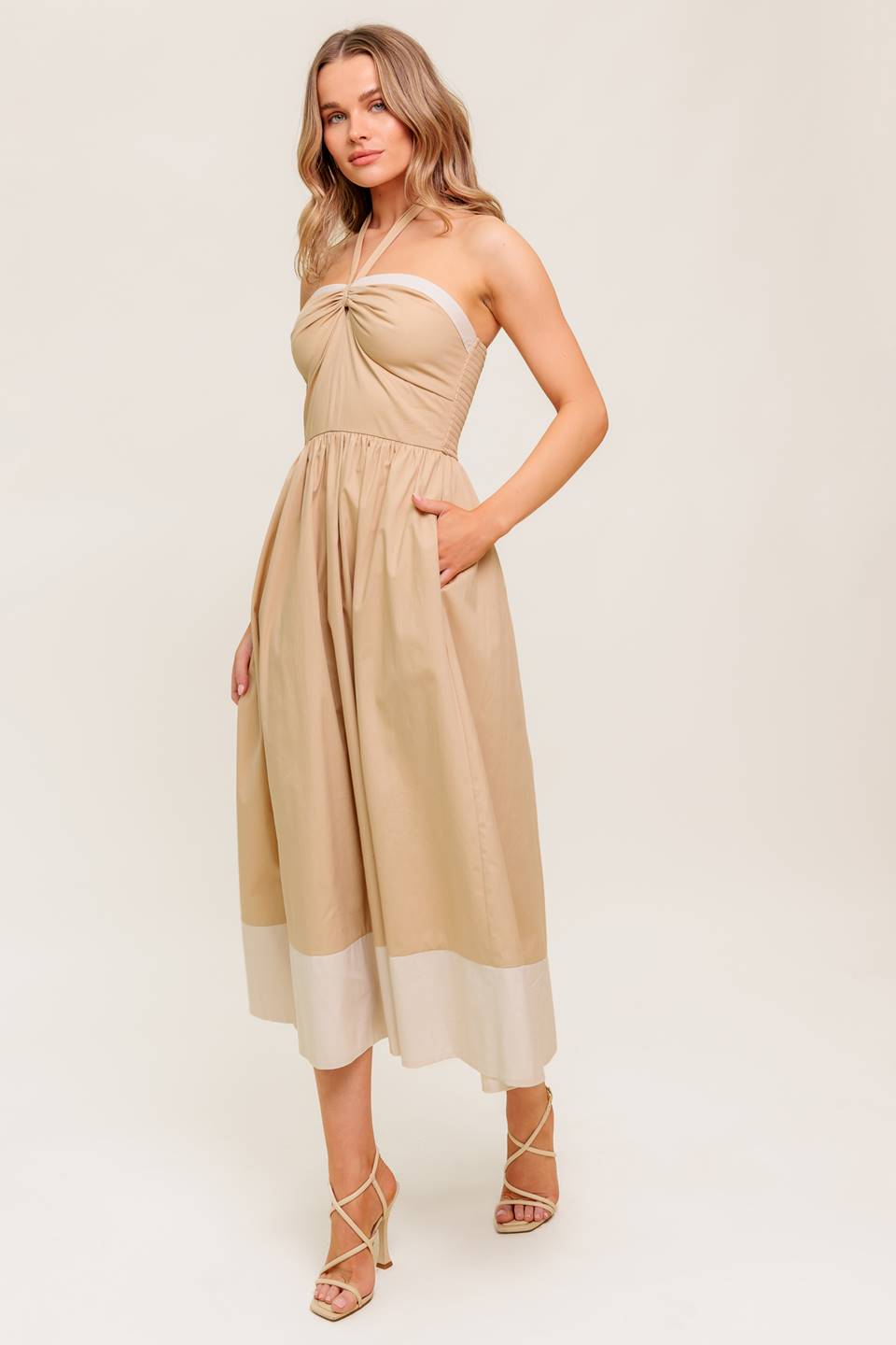 A solid woven midi dress featuring sweetheart neckline with gathered front, halter tie, full skirt and smocked back bodice.