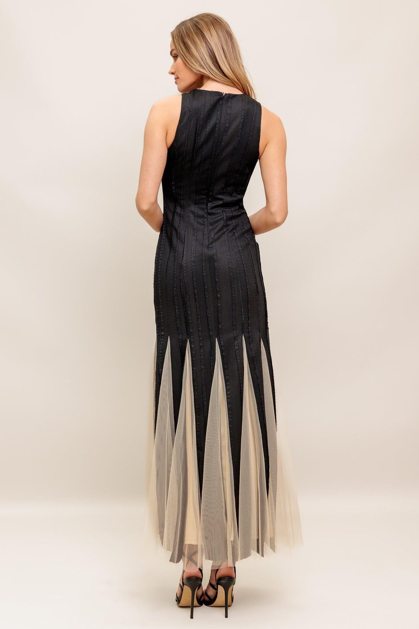 A solid knit maxi dress featuring round neckline, sleeveless, tulle inset bottom and back zipper closure