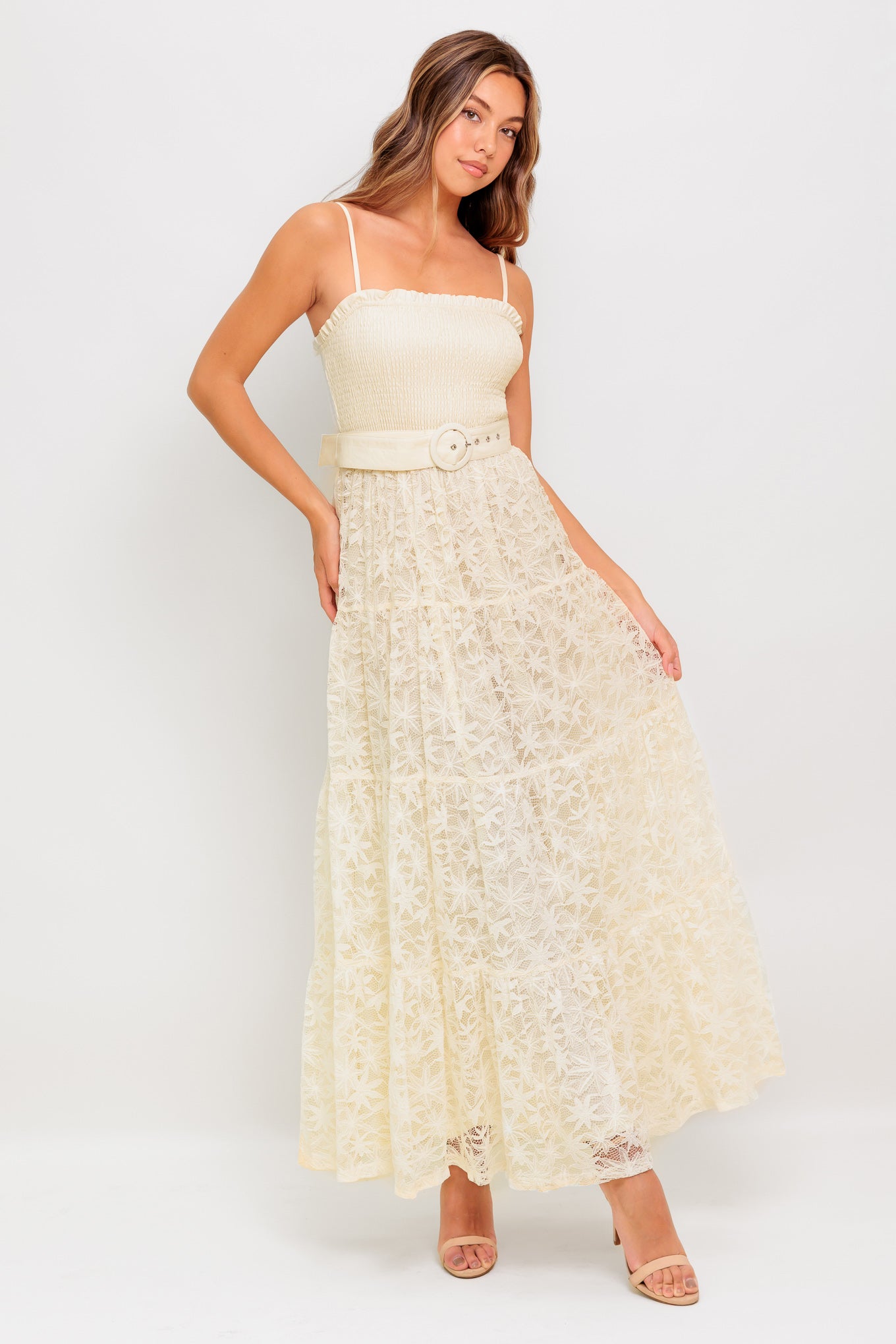 A woven lace ankle length dress featuring straight neckline with ruffled edge, smocked bodice, straps, self belt and tiered skirt